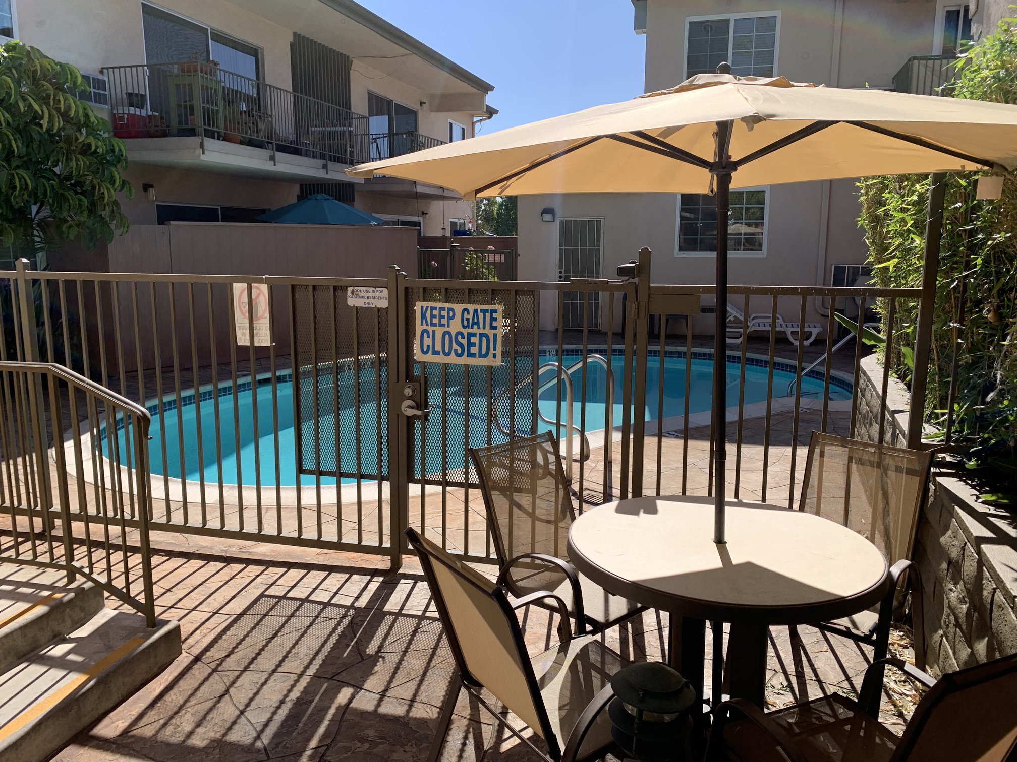 a patio with a table and chairs next to a swimming pool